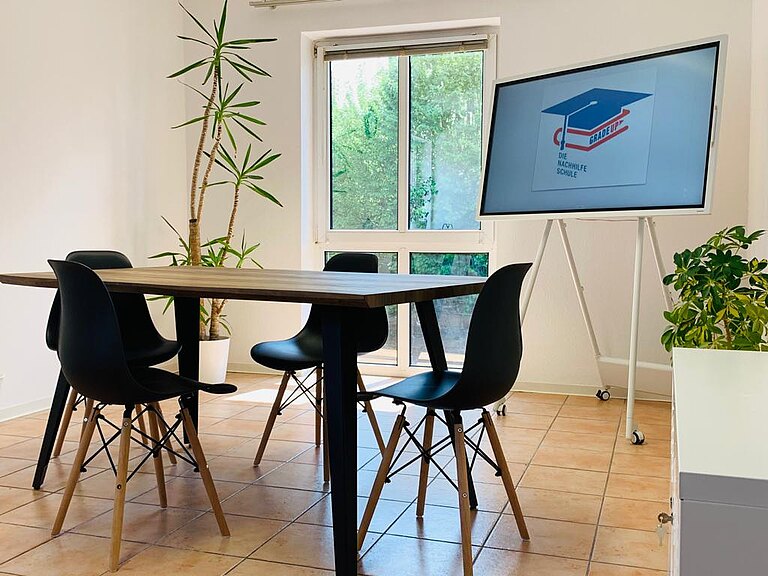 Foto von Raum 1 mit digitaler Tafel und Blumen in den Ecken